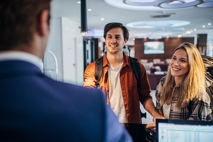 Smiling travelers checking in at Holiday Inn Nashville Airport for a weekend stay near BNA and downtown Nashville